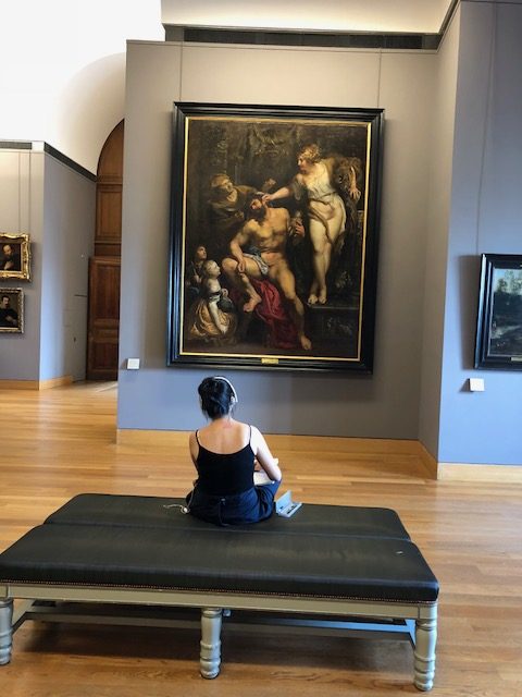 Visitor sitting, drawing the painting in front of her 