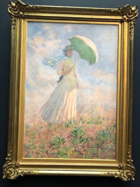 Woman in a field carrying an umbrella