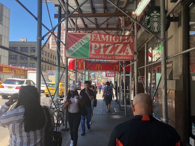 Famiglia Pizza sign over sidewalk