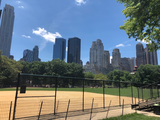 A baseball diamond with skyscrapers beind it