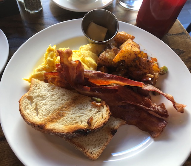 Breafkast: scrambled eggs, bacon, potatoes, sourdough toast