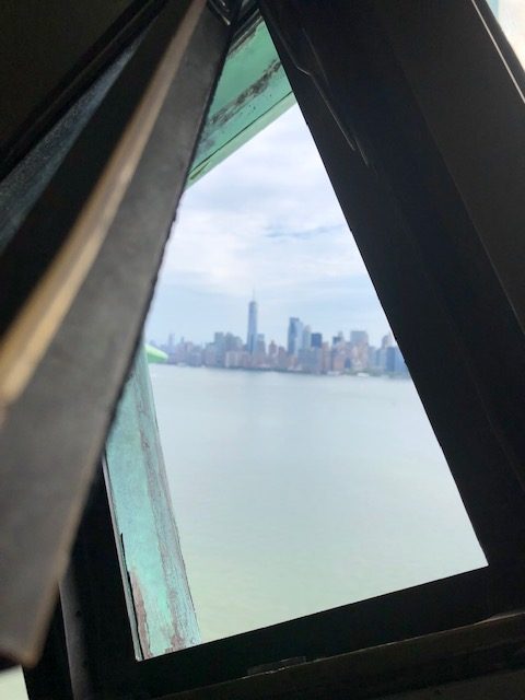 A tiny windwo latched open from the crown, with the World Trade Center in the center
