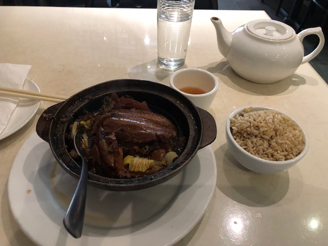 Braised pork and cabbage in a small pot, brown rice on the side