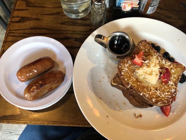 French toast with strawberries, blueberries and mascarpone butter, and a side of sausage
