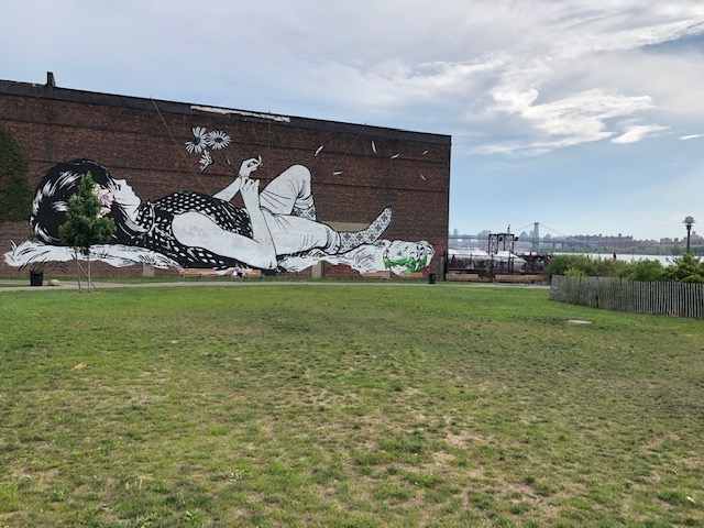 A mural on a walk of a girl lieing on her back, like looking at the clouds. Maybe 80 x 20.