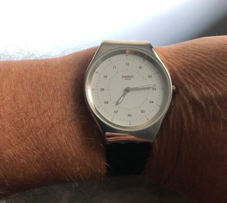 Simple silver watch with a white face, actual numbers for the clock