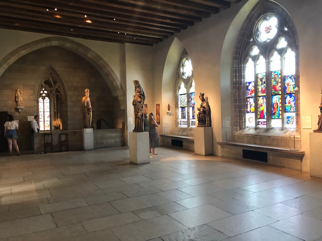 Room with stained glass windows and many sculptures