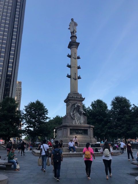 Statue of Christopher Columbus high on a pedestal, at least 3 storie up