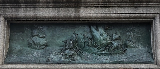 Closeup of a bronze relief done of ships from 1492, on the pedestal
