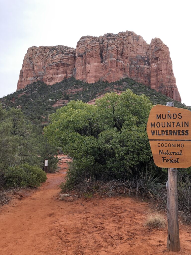 Courthouse Butte in the background, sign in front says Munds Mountain Wilderness, Coconino National Forest