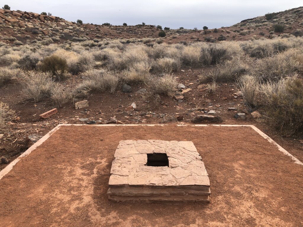 A square platform about 6x6, red dirt base, with a smaller stone platfrom in the midle, made of stone, about 2.5 ft square. A square hole in the middle of that, may 8in square. That's the blow hole.