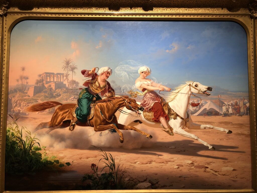An Arabian girl riding a white horse, being chased by an Arabian man on a brown horse. 