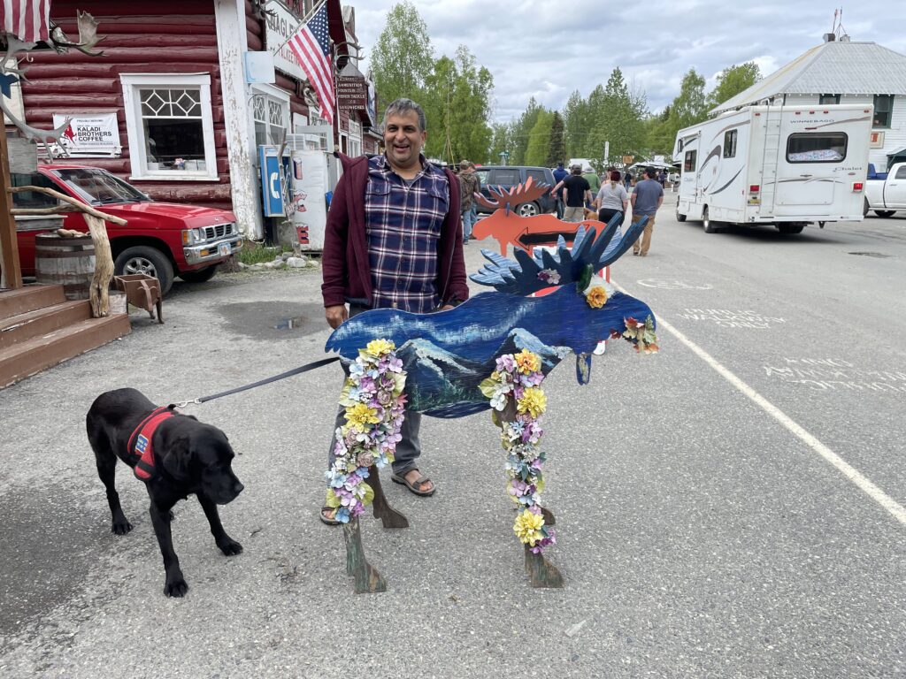 A wooden blue moose decorated in flowers. 