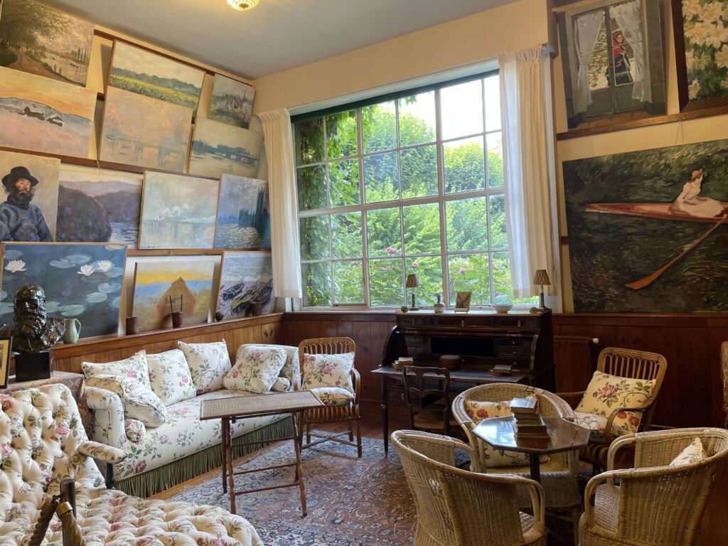 Paintings on the left wall, huge window in the center. 