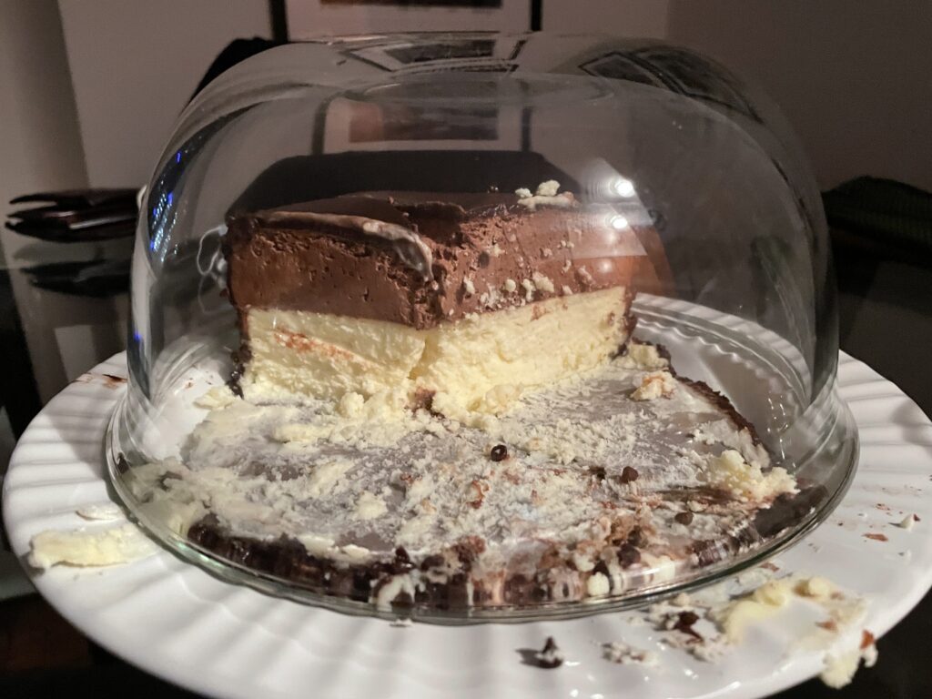 photo of the dessert after being cut - two inches of mousse on top of two inches of cheesecake, with a chocolate frosting