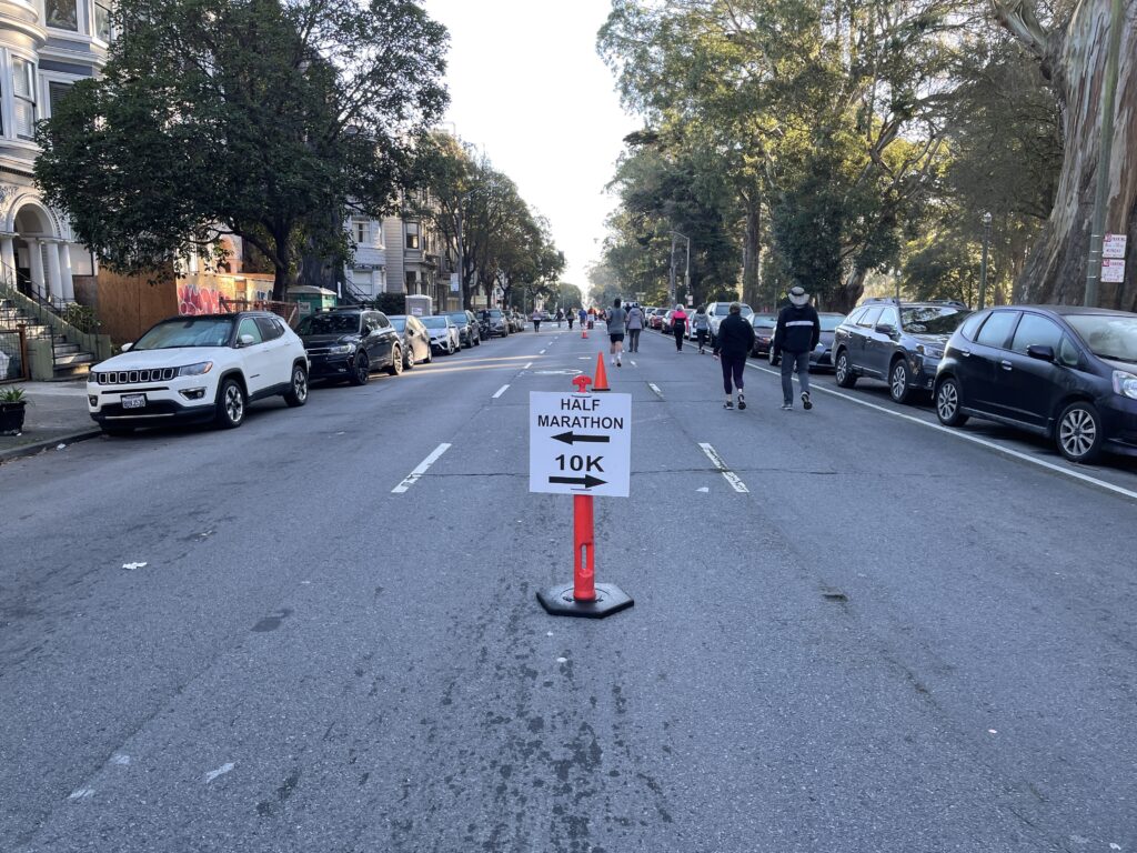 Sign in the middle of the street signifying 10k on the right and marathon on the left. 