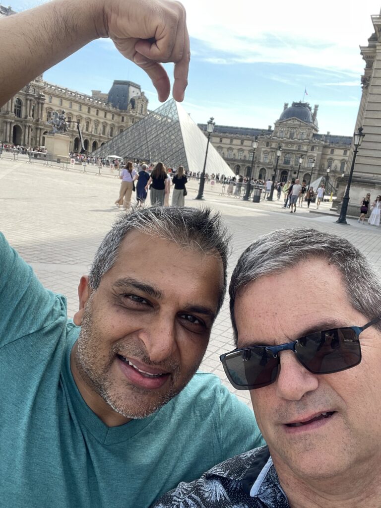 Selfie of us with Ash posing his fingers over the top of the pyramid at the Louvre. 