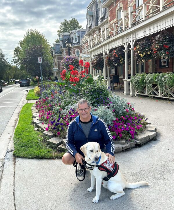 Me sitting with Zeus at the start of the main drag with quaint buildings and gardens behind us